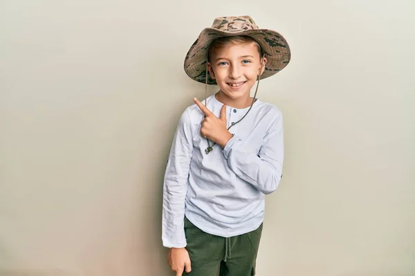 小さなCaucasian男の子子供身に着けている探検家の帽子笑顔陽気な指すとともに手と指アップザ側 — ストック写真