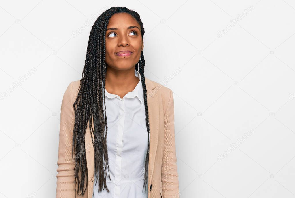 African american woman wearing business jacket smiling looking to the side and staring away thinking. 