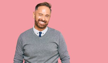 Yakışıklı, orta yaşlı, iş kıyafetleri giyen, kameraya seksi bir ifadeyle bakan, neşeli ve mutlu yüzlü bir adam.. 