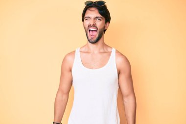 Yaz görünüşlü yakışıklı İspanyol adam ve güneş gözlüğü takan seksi bir ifadeyle kameraya bakan neşeli ve mutlu yüzlü.. 