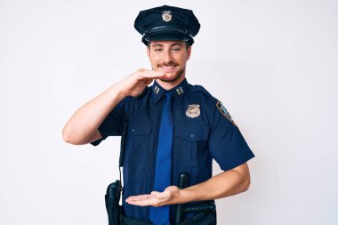 Polis üniforması giyen, elleri büyük ve büyük boy işareti gösteren beyaz bir genç. Ölçü sembolü. Kameraya bakıp gülümsüyor. ölçüm kavramı. 