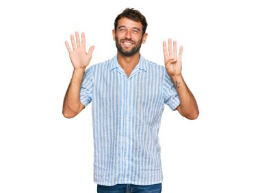 Sakallı yakışıklı genç adam, günlük temiz gömleğini giyiyor ve dokuz numarayı gösterip gülümsüyor. Kendinden emin ve mutlu.. 