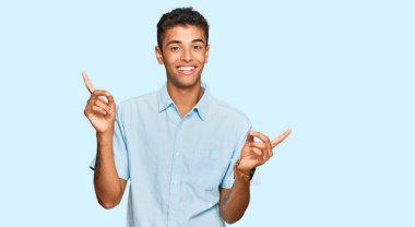 Genç, yakışıklı, Afro-Amerikalı, günlük kıyafetler giyen, kendine güvenen, farklı yönleri gösteren, kendine güvenen bir adam. reklam için kopyalama alanı 