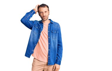 Gündelik kıyafetler giyen genç yakışıklı adam kafaları karıştırır ve soru sorar. Şüpheyle kararsız, kafa kafaya düşünerek. Düşünceli kavram. 