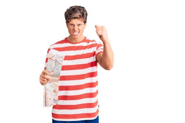 Şehir haritasını tutan genç yakışıklı adam sinirlenmiş ve sinirlenmiş öfkeyle bağırıyor, öfkeyle bağırıyor ve el kaldırıyor. 