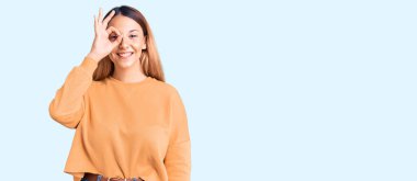 Güzel, genç bir kadın günlük kıyafetler giyiyor. El hareketleriyle gülümsüyor, gözleriyle mutlu yüzlere bakıyor.. 