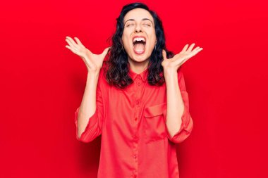 Genç ve güzel İspanyol kadın gündelik giysiler giyip başarının çılgınlığını kutluyor. Kollarını kaldırmış, gözlerini kapatmış heyecanlı çığlıklar atıyor. Kazanan konsept 