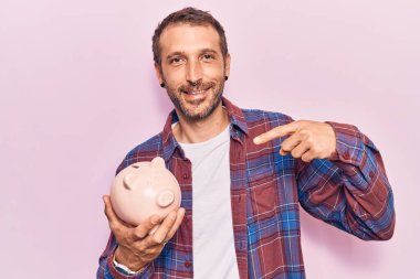 Kumbarayı tutan yakışıklı genç adam gülümsüyor. 