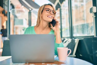 Kahve dükkanının terasında çalışan genç sarışın kadın..