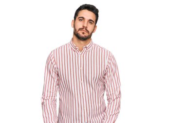 İş gömleği giyen genç İspanyol adam yüzünde ciddi bir ifadeyle rahatlamış. Basit ve doğal bir şekilde kameraya bakıyorsun.. 