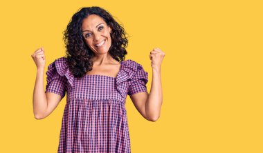 Orta yaşlı güzel bir kadın gündelik kıyafet giymiş gururla bağırıyor zaferi ve başarıyı kutluyor kollarını kaldırarak heyecanla bekliyor. 