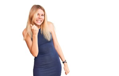 Genç, güzel, sarışın bir kadın. Kızgın ve kızgın. Öfkeyle bağırırken yumruğunu kaldırıyor. öfke ve agresif konsept. 