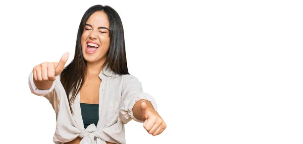 若い美しいヒスパニック系の女の子は 手で積極的なジェスチャーを行うことを承認カジュアル服を着て 親指を笑顔と成功のために幸せ 勝者のジェスチャー — ストック写真