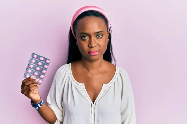 Jonge Afrikaanse Vrouw Met Pillen Denken Houding Nuchtere Uitdrukking Zoek — Stockfoto