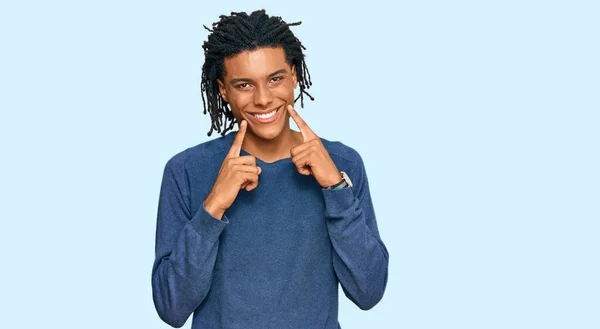 스웨터를 벌리고 웃으며 손가락을 가리키고 미소를 강요하는 아프리카계 미국인 — 스톡 사진