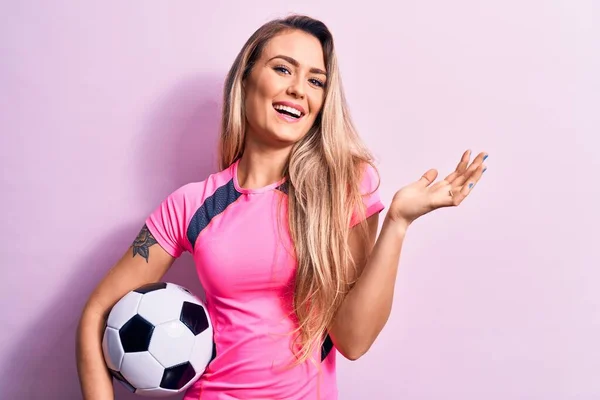 Genç Sarışın Bir Kadın Futbol Topunu Pembe Arka Planda Tutarak — Stok fotoğraf