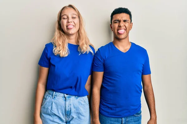 Joven Pareja Interracial Que Usa Ropa Casual Sacando Lengua Feliz —  Fotos de Stock