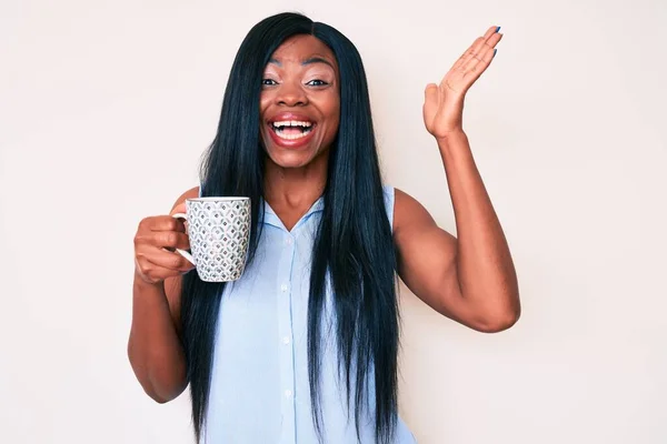 Joven Mujer Afroamericana Sosteniendo Café Celebrando Victoria Con Sonrisa Feliz —  Fotos de Stock