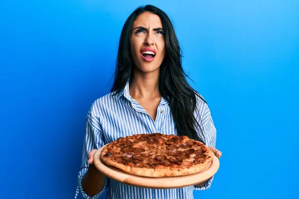 Mulher Hispânica Bonita Segurando Saborosa Pizza Pepperoni Irritado Louco Gritando — Fotografia de Stock