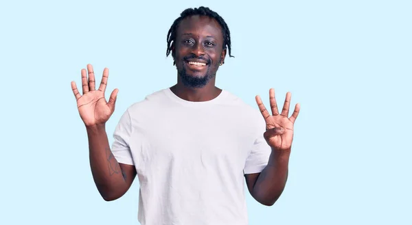 自信と幸せ笑みを浮かべている間 カジュアルな白いTシャツを着て 指の番号9で指摘している若いアフリカ系アメリカ人の男 — ストック写真