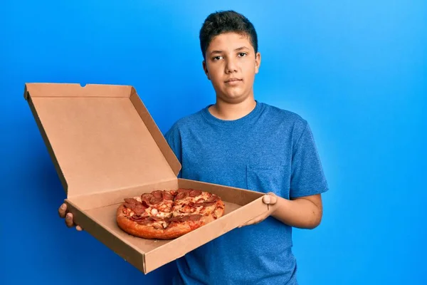 Teenager Hispánský Chlapec Jíst Chutné Feferonkové Pizzy Uvolněný Vážným Výrazem — Stock fotografie