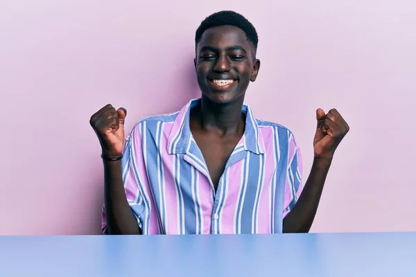 Mladý Afroameričan Neformálním Oblečení Sedí Stole Velmi Šťastný Vzrušený Dělá — Stock fotografie