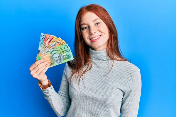 Menina Cabeça Vermelha Jovem Segurando Dólares Australianos Olhando Positivo Feliz — Fotografia de Stock