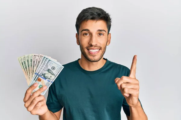 Joven Hombre Guapo Sosteniendo Dólares Sonriendo Con Una Idea Pregunta — Foto de Stock