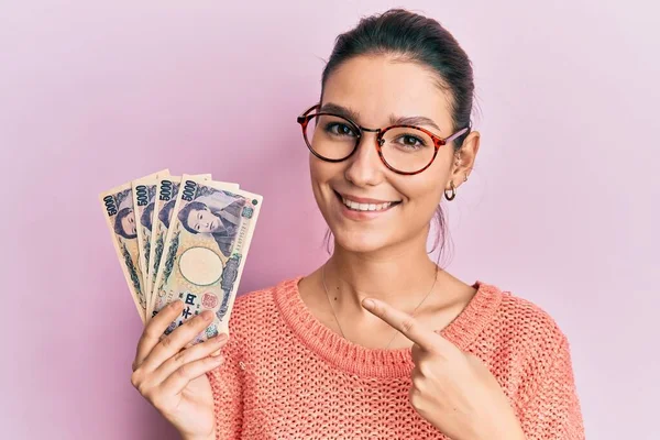 Young Caucasian Woman Holding Japanese Yen Banknotes Smiling Happy Pointing — Stock Photo, Image