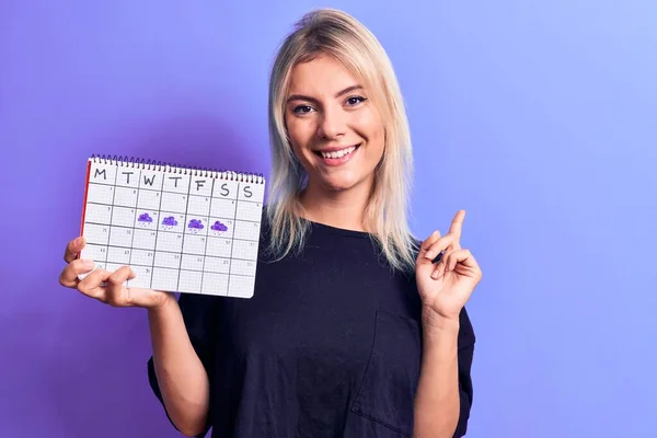 Vacker Blond Kvinna Som Håller Väder Kalender Visar Regnig Vecka — Stockfoto