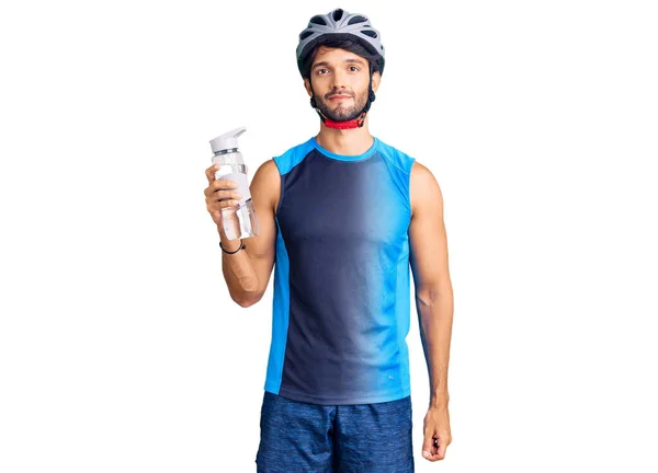 Bonito Homem Hispânico Vestindo Capacete Bicicleta Segurando Garrafa Água Pensando — Fotografia de Stock