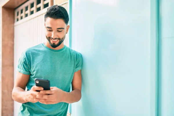 Jovem Árabe Homem Sorrindo Feliz Usando Smartphone Cidade — Fotografia de Stock