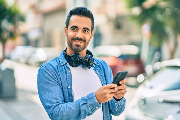 Ung Latinamerikansk Man Ler Glad Med Smartphone Och Hörlurar Stan — Stockfoto