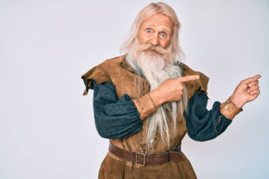 Gri saçlı, uzun sakallı, Viking kostümü giyen yaşlı bir adam endişeli ve gergin bir tarafı işaret ediyor, endişeli ve şaşırmış bir ifadeyle. 