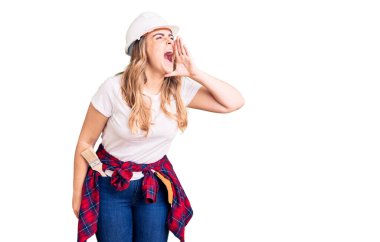 Güvenlik kaskı takan beyaz bir kadın el ele verip bağırıyor. iletişim konsepti. 