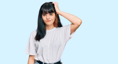 Gündelik kıyafetler giyen genç İspanyol kız soru sorup kafasını karıştırıyor. Şüpheyle kararsız, kafa kafaya düşünerek. Düşünceli kavram. 