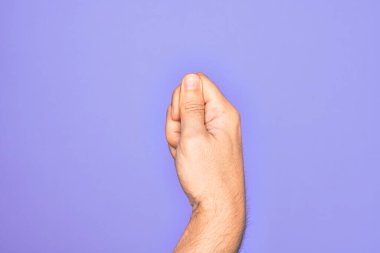 İzole edilmiş mor arka planda parmaklarını gösteren beyaz bir gencin eli parmak, iş ve reklamla boş bir alan tutuyor.