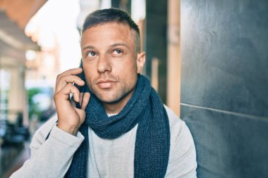 Kafkasyalı, rahat yüzlü, şehirdeki akıllı telefondan konuşan genç bir adam..