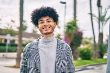 Genç Afrikalı Amerikalı iş adamı şehirde mutlu mesut dikiliyor..