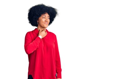 Genç Afrikalı Amerikalı kız gündelik kıyafetler giyiyor. Ağrılı boynuna dokunuyor. Grip, mantar ve enfeksiyon yüzünden boğazı ağrıyor. 