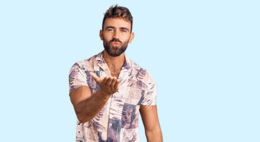 Yaz kıyafetleri giymiş genç İspanyol bir adam kameraya bakıyor. Canlı yayında öpüşüyor. Güzel ve seksi. aşk ifadesi. 