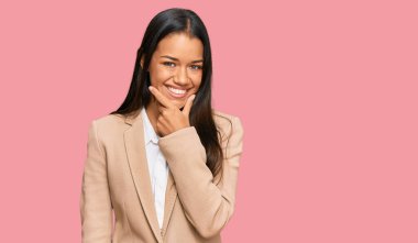 Güzel İspanyol kadın iş ceketi giyiyor kameraya kendinden emin bakıyor kollarını kavuşturup gülümsüyor ve çenesini kaldırıyor. Olumlu düşünmek. 