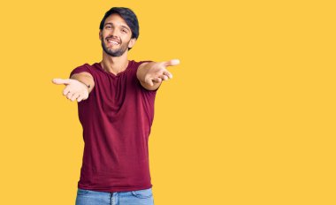 Yakışıklı, sıradan kıyafetler giyen, kameraya bakıp kucaklaşmak için gülümseyen bir İspanyol. Mutluluğu kucaklayan neşeli bir ifade.. 