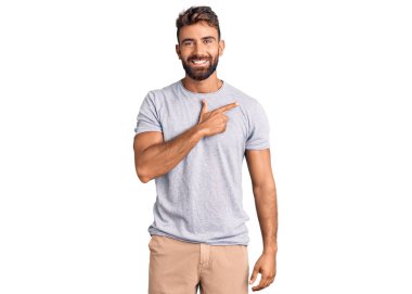 Gündelik kıyafetler giyen, neşeli, yüzünde gülümseme olan genç İspanyol adam mutlu ve doğal bir ifadeyle elini ve parmağını kaldırdı. 