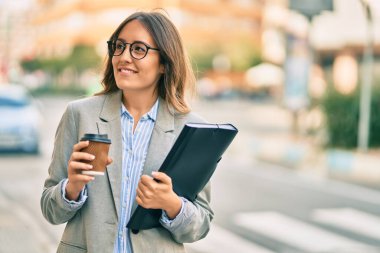 Latin kökenli genç iş kadını şehirde kahve içiyor..