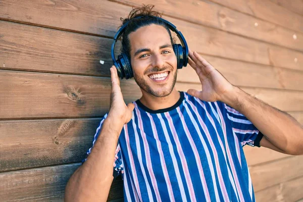 Joven Hombre Hispano Sonriendo Feliz Escuchando Música Usando Auriculares Ciudad —  Fotos de Stock