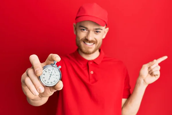 Junger Rothaariger Mann Lieferuniform Und Countdown Uhr Lächelt Glücklich Und — Stockfoto