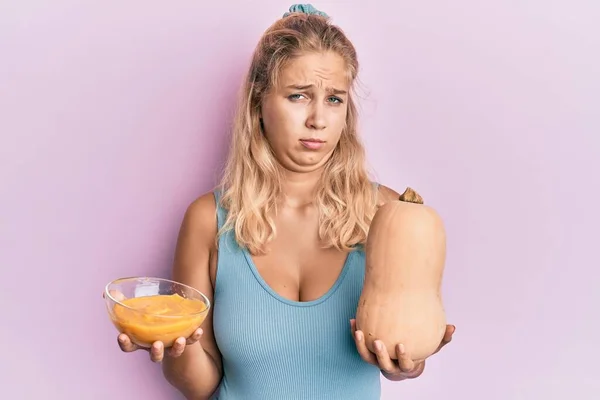 Menina Loira Jovem Segurando Abóbora Fresca Sopa Sem Noção Expressão — Fotografia de Stock