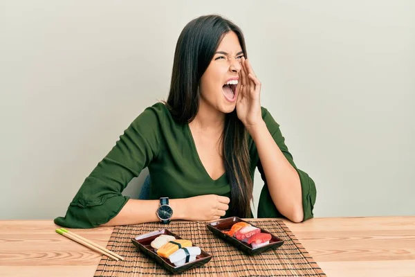 Joven Morena Comiendo Sushi Sentada Mesa Gritando Gritando Fuerte Lado — Foto de Stock