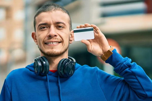 Joven Hispano Usando Auriculares Con Tarjeta Crédito Ciudad —  Fotos de Stock